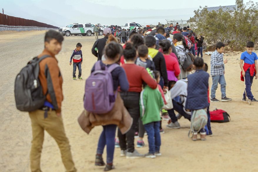 This Monday, Jan. 14, 2019 photo released by U.S. Customs and Border Protection shows some of 376 Central Americans the Border Patrol says it arrested in southwest Arizona, the vast majority of them families, who used short holes dug under a barrier to cross the border in multiple spots about 10 miles east of San Luis, Ariz. The unusually large group was almost entirely from Guatemala. (U.S. Customs and Border Protection via AP)