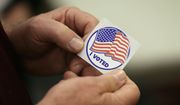 In this May 8, 2018, file photo, a person holds a sticker after placing his vote at the Durham County Library North Regional in Durham, N.C. (AP Photo/Gerry Broome, File)