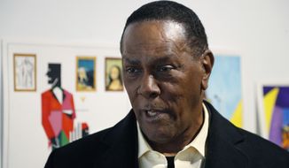 In this Thursday, Jan. 17, 2019 photo, Richard Phillips stands next to some of his artwork during an interview at the Community Art Gallery in Ferndale, Mich. Phillips was exonerated of murder in 2018 after 45 years in prison. Lawyers say he should be entitled to more than $2 million under Michigan&#39;s wrongful conviction law, but the state so far is resisting. So Phillips, 73, is selling some of his 400-plus watercolors that he painted in prison. (AP Photo/Carlos Osorio)