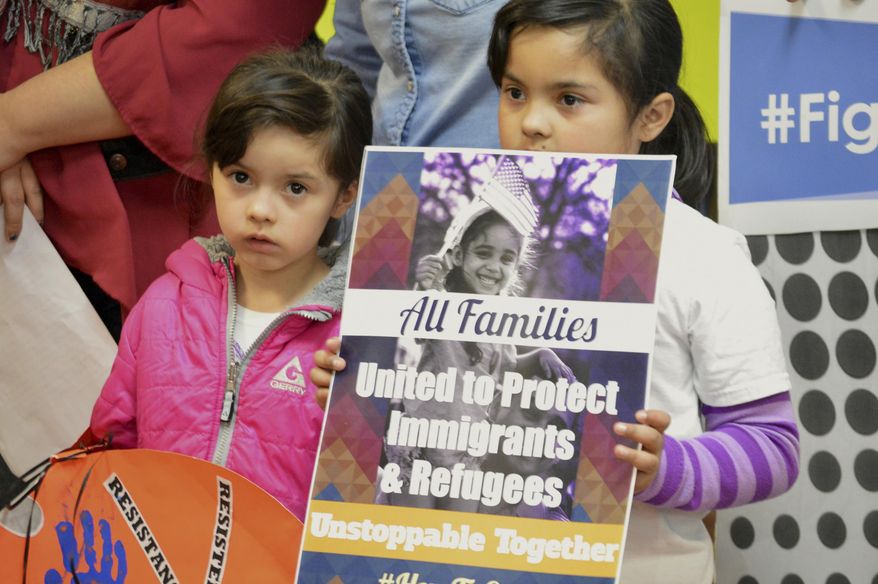 FILE - In this Jan. 25, 2017 file photo, Jocelynn Lujan, left, and her sister, Jennifer, attend a news conference in Albuquerque, N.M., where activists denounced President Donald Trump's executive actions on immigration. Identical Democratic proposals in the New Mexico House and Senate would prevent state agencies from cooperating with federal immigration authorities and limit the authority of sheriffs and jails to hold federal immigrant detainees. (AP Photo/Russell Contreras, File)