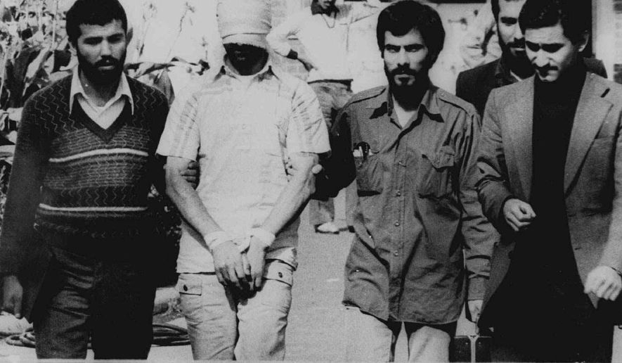 FILE - In this Nov. 9, 1979 file photograph, one of the hostages seized when Islamic radicals stormed the U.S. Embassy in Tehran, blindfolded and with his hands bound, is displayed to a crowd in Tehran, Iran. This climactic event and others in 1979, which dominated television sets and newspaper front pages 40 years ago, helped shape the modern Middle East. (AP Photo, File)