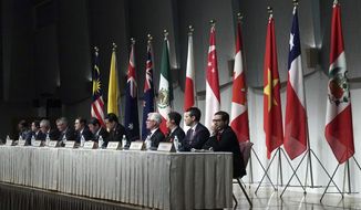 Toshimitsu Motegi, Japan&#39;s minister of economy, trade, and industry, sits with other ministers and delegates of a Pacific Rim trade bloc, attend a joint press conference after a session of the Comprehensive and Progressive Trans-Pacific Partnership (CPTPP) in Tokyo Saturday, Jan. 19, 2019. Trade ministers of a Pacific Rim trade bloc are meeting in Tokyo, gearing up to roll out and expand the market-opening initiative. (AP Photo/Eugene Hoshiko)