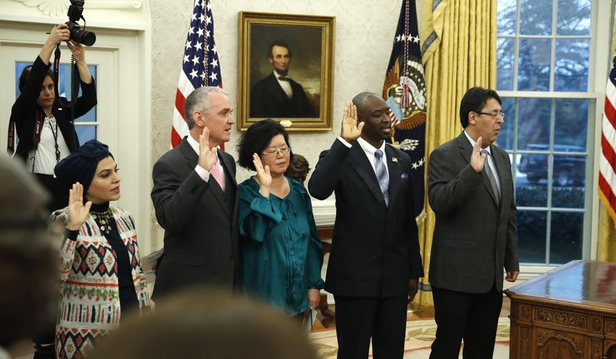 The five people being naturalized as American citizen, take the oath of allegiance in the Oval Office of the White House, in Washington, Saturday, Jan. 19, 2019. (AP Photo/Alex Brandon)
