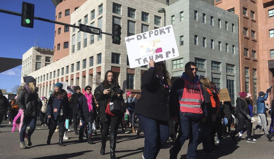 Demonstrators rally at the Women's March in Denver, Colo., on Saturday, Jan. 19, 2019. The marchers stretched for several blocks, and officers blocked off streets around the state Capitol and city hall to clear their path. (AP Photo/Dan Elliot)