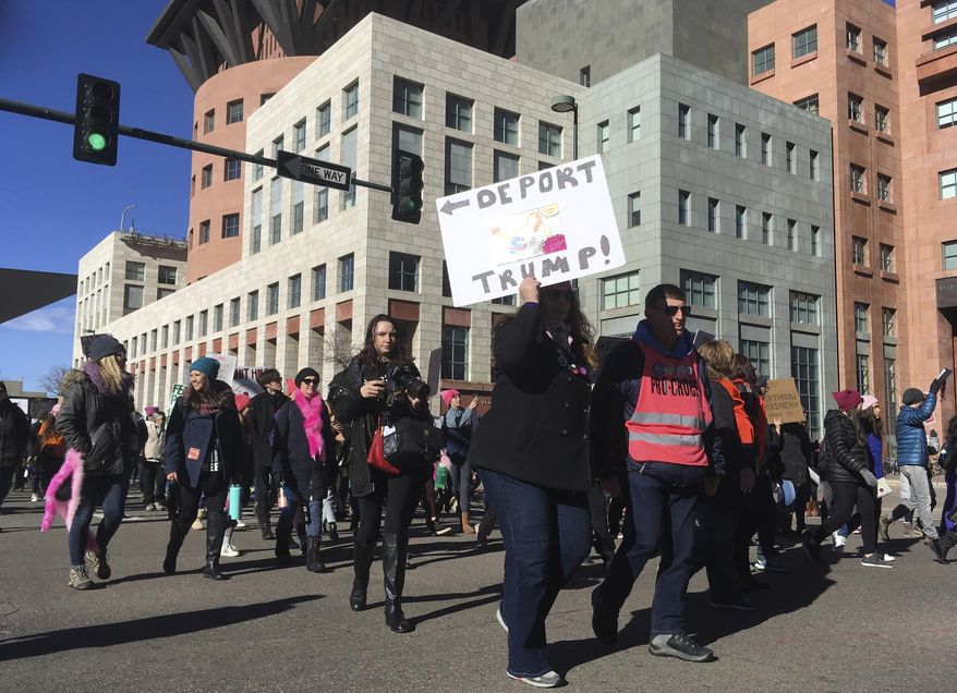 Demonstrators rally at the Women's March in Denver, Colo., on Saturday, Jan. 19, 2019. The marchers stretched for several blocks, and officers blocked off streets around the state Capitol and city hall to clear their path. (AP Photo/Dan Elliot)