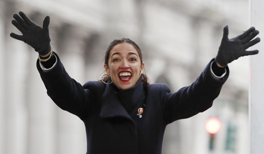 U.S. Rep. Alexandria Ocasio-Cortez, (D-New York) waves to the crowd as she steps onto the stage at the Women&#39;s Unity Rally organized by Women&#39;s March NYC in Lower Manhattan, Saturday, Jan. 19, 2019, in New York. (AP Photo/Kathy Willens)