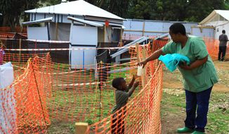 A health worker feeds a boy suspected of having the Ebola virus at treatment center in Beni, Eastern Congo on Sept. 9, 2018. Responders are seeing &quot;sporadic&quot; cases of Ebola in four cities. (ASSOCIATED PRESS)