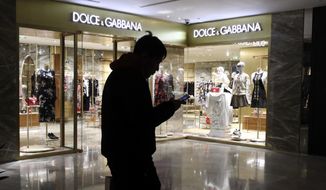 FILE - In this Nov. 21, 2018, file photo, a man walks past an outlet of Dolce &amp;amp; Gabbana in Beijing. Chinese model Zuo Ye in advertisements for Italian fashion line Dolce &amp;amp; Gabbana that were widely derided in the country apologized for her appearance in the campaign. (AP Photo/Ng Han Guan, File)