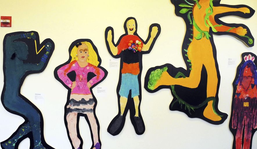 In this November 2013 photo provided by Marygrace Berberian, students share artwork from school-based art therapy workshops at "Standing Tall," a public exhibit at New York University in New York. Arts and crafts are getting renewed attention as a way to teach social and emotional skills to kids at school and during extracurricular activities. Experts advise giving kids the freedom to express their own experiences through art projects. Creating together with other kids or parents also helps. (Ken Hutchinson/Marygrace Berberian via AP)