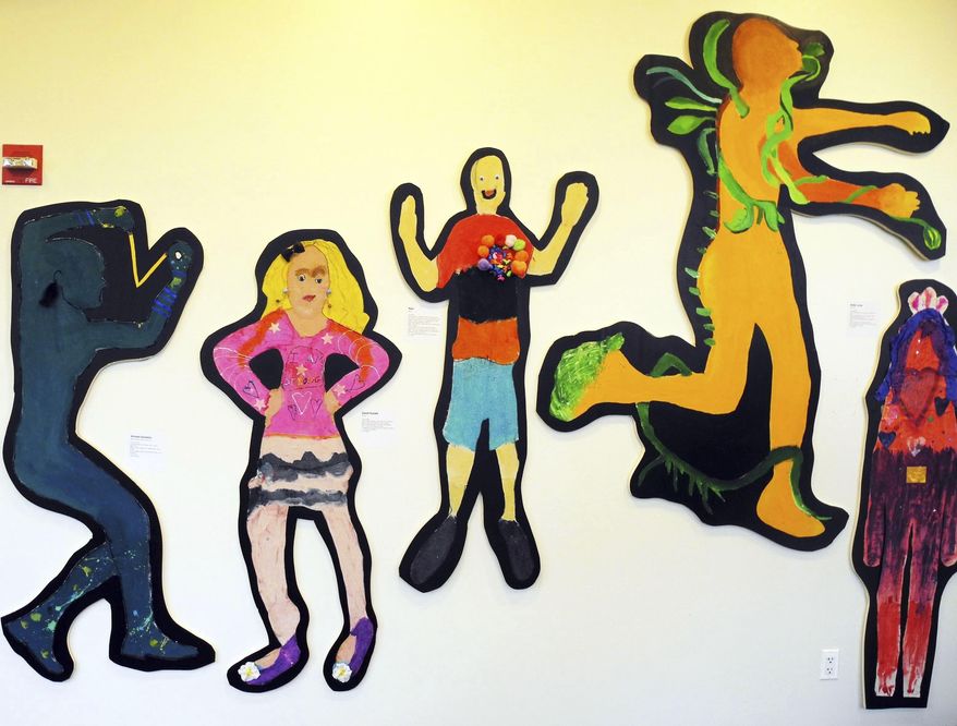 In this November 2013 photo provided by Marygrace Berberian, students share artwork from school-based art therapy workshops at "Standing Tall," a public exhibit at New York University in New York. Arts and crafts are getting renewed attention as a way to teach social and emotional skills to kids at school and during extracurricular activities. Experts advise giving kids the freedom to express their own experiences through art projects. Creating together with other kids or parents also helps. (Ken Hutchinson/Marygrace Berberian via AP)