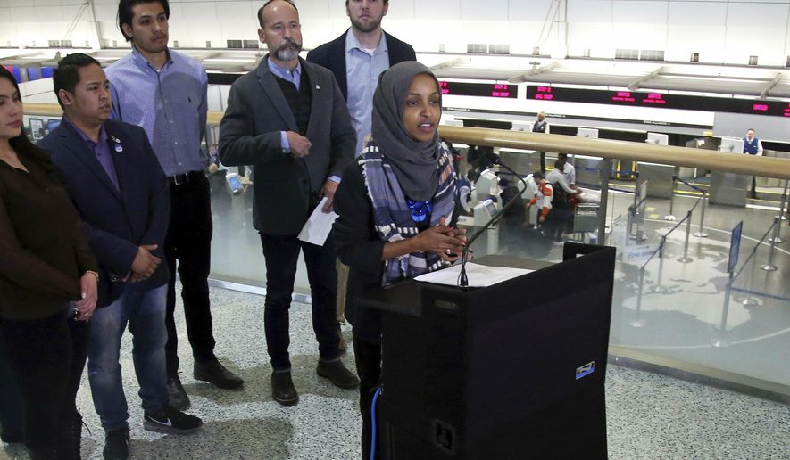Rep. Ilhan Omar (D-Minn), right, addresses a news conference Tuesday, Jan. 22, 2019 at the Minneapolis-St. Paul International Airport accompanied by constituents behind her affected by the government shutdown, called for an end to the shutdown. (AP Photo/Jim Mone)