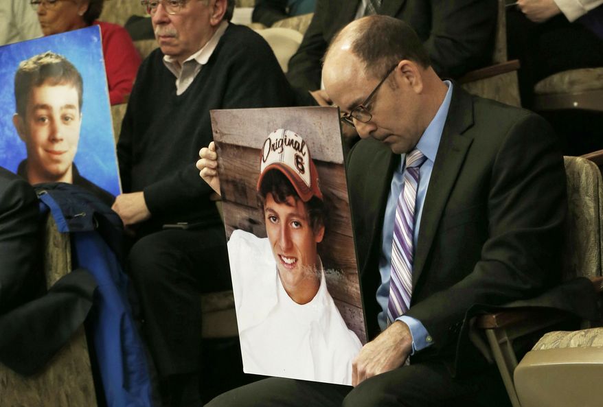 Greg LaVallee, right, holds a photo of his son who was killed by a driver using a cell phone after he testified before a hearing Tuesday, Jan. 22, 2019 at the State Capitol in St. Paul, Minn. in support of a bill requiring drivers use only hands-free cell phones while driving. Several witnesses who lost loved ones testified in support of the bill. (AP Photo/Jim Mone)