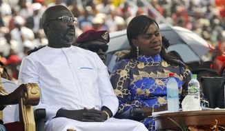 FILE - In this Jan. 22, 2018, file photo, Liberia&#39;s new President George Weah, left and his wife, Clar Weah, right, sit during his inauguration ceremony in Monrovia Liberia. Star footballer-turned-politician George Weah marks a year as Liberia&#39;s president on Tuesday Jan. 22, 2019, as many in the impoverished country debate whether he has begun to deliver on dramatic campaign promises. FIFA&#39;s 1995 player of the year in his inaugural speech vowed to give the West African nation&#39;s young population hope through job creation and a war on corruption, saying &amp;quot;Liberians will no longer be spectators in their own economy.&amp;quot; (AP Photo/Abbas Dulleh, File)