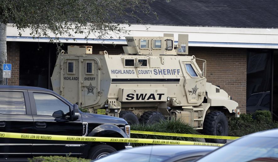 A Highlands County Sheriff's SWAT vehicle is stationed out in front of a SunTrust Bank branch, Wednesday, Jan. 23, 2019, in Sebring, Fla., where authorities say five people were shot and killed. (AP Photo/Chris O'Meara)