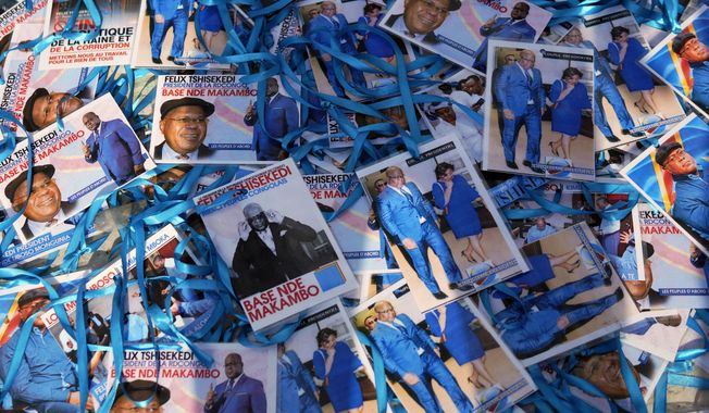 Supporters of Congolese President elect Felix Tshisekedi sell souvenirs outside his party headquarters in Kinshasa, Democratic Republic of the Congo, Wednesday Jan. 23, 2019. Tshisekedi is to be inaugurated Thursday Jan. 24, 2019, having won an election that raised numerous concerns about voting irregularities amongst observers as the country chose a successor to longtime President Joseph Kabila. (AP Photo/Jerome Delay)