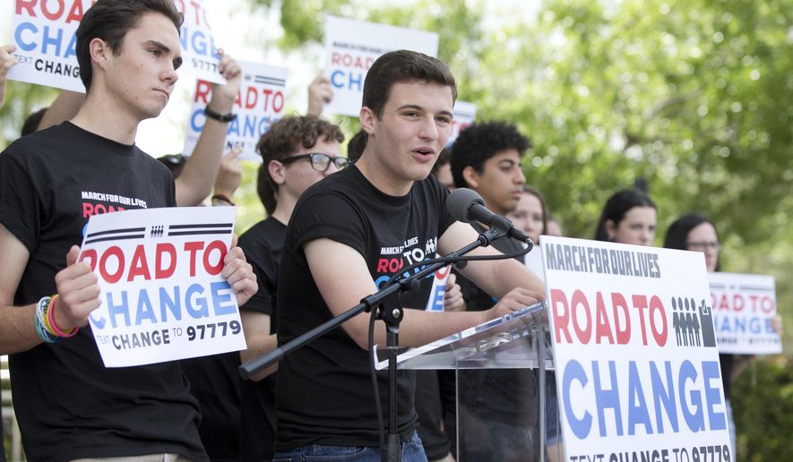 FILE- In this June 4, 2018 file photo, Cameron Kasky, center, speaks during a news conference in Parkland, Fla., announcing a multistate bus tour to get young people educated, registered and motivated to vote. Young Florida voters hit the polls at a significantly higher rate compared to the previous midterm election. About 37 percent of 18 to 29 year-olds voted in November. That's a 15 point increase compared to the 22 percent who voted in 2014 and especially notable for midterm elections when turnout is typically low(AP Photo/Wilfredo Lee)