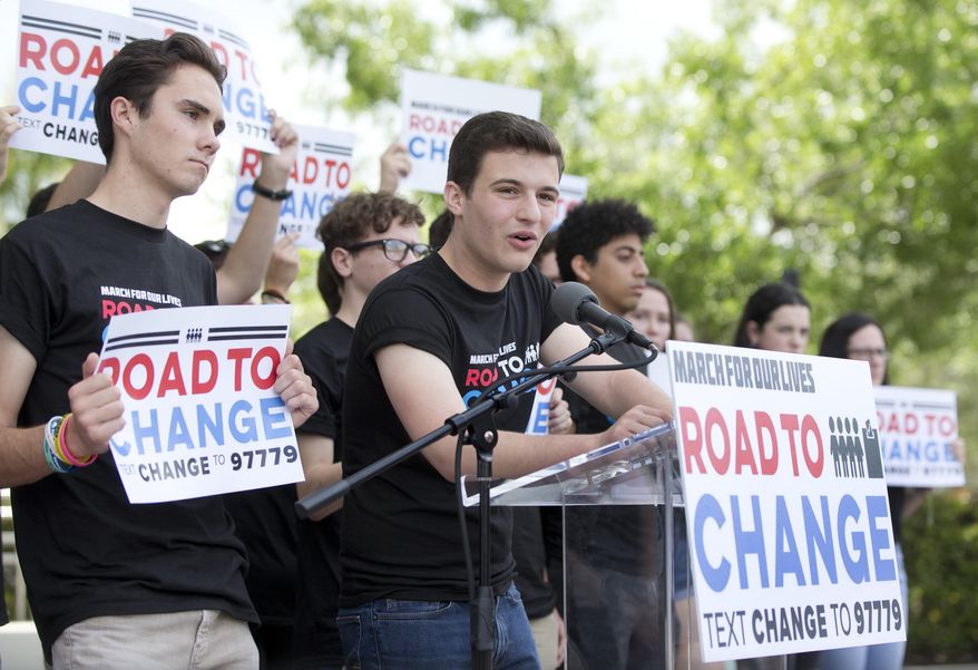 FILE- In this June 4, 2018 file photo, Cameron Kasky, center, speaks during a news conference in Parkland, Fla., announcing a multistate bus tour to get young people educated, registered and motivated to vote. Young Florida voters hit the polls at a significantly higher rate compared to the previous midterm election. About 37 percent of 18 to 29 year-olds voted in November. That's a 15 point increase compared to the 22 percent who voted in 2014 and especially notable for midterm elections when turnout is typically low(AP Photo/Wilfredo Lee)