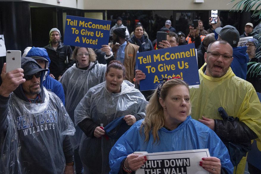 Furloughed government workers protest the government shutdown at the door of U.S. Sen. Mitch McConnell's office in Lexington, Ky., Wednesday, Jan 23, 2019. (AP Photo/Bryan Woolston)