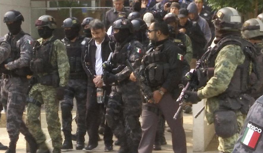 FILE - In this May 2, 2017 file photo, Damaso Lopez, a leader in Mexico's Sinaloa drug cartel, is escorted by police after his capture at an upscale apartment building in Mexico City. Lopez testified Wednesday, Jan. 23, 2019, at the U.S. trial of the Mexican drug lord known as El Chapo, implicating the kingpin's wife in his 2015 prison escape. (AP Photo/Jorge Barrera, File)