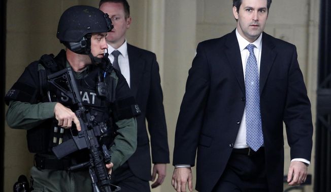 FILE- In this Dec. 5, 2016 file photo, Michael Slager, at right, walks from the Charleston County Courthouse under the protection from the Charleston County Sheriff&#x27;s Department after a mistrial was declared for his trial in Charleston, S.C.  Attorneys have asked an appellate court to reconsider its ruling upholding the conviction and 20-year sentence of Slager,, a former South Carolina policeman in the shooting death of an unarmed motorist who was running away from a traffic stop.  (AP Photo/Mic Smith, File)