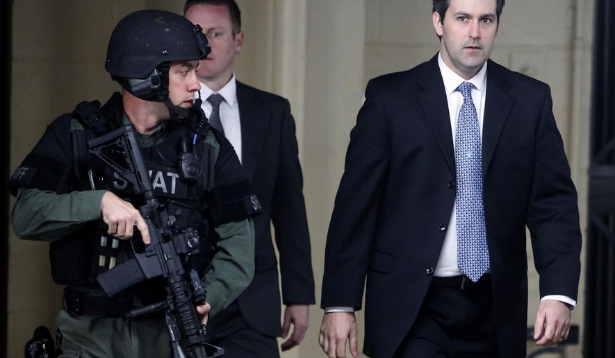 FILE- In this Dec. 5, 2016 file photo, Michael Slager, at right, walks from the Charleston County Courthouse under the protection from the Charleston County Sheriff's Department after a mistrial was declared for his trial in Charleston, S.C.  Attorneys have asked an appellate court to reconsider its ruling upholding the conviction and 20-year sentence of Slager,, a former South Carolina policeman in the shooting death of an unarmed motorist who was running away from a traffic stop.  (AP Photo/Mic Smith, File)