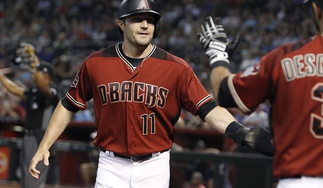 FILE - In this  Sunday, July 22, 2018 file photo, Arizona Diamondbacks' A.J. Pollock (11) is congratulated by teammate Daniel Descalso after scoring a run against the Colorado Rockies on a Steven Souza double during the first inning of a baseball game in Phoenix. A person familiar with the negotiations says free-agent outfielder AJ Pollock and the Los Angeles Dodgers have agreed to a $55 million, four-year contract. The person spoke Thursday, Jan. 24, 2019 on condition of anonymity because the agreement has not been announced (AP Photo/Ralph Freso, File)