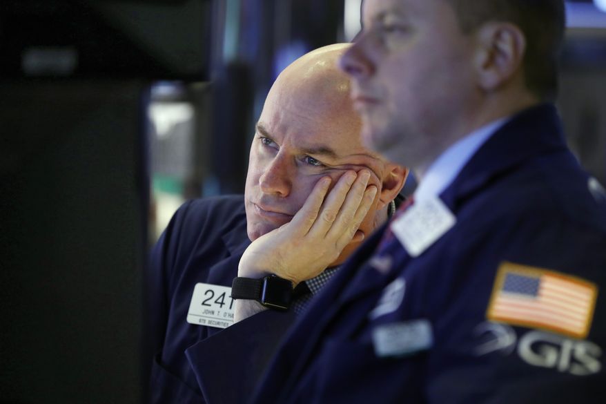 FILE- In this Jan. 11, 2019, file photo, Specialist John O'Hara, left, works on the floor of the New York Stock Exchange. The U.S. stock market opens at 9:30 a.m. EST on Thursday, Jan. 24. (AP Photo/Richard Drew, File)