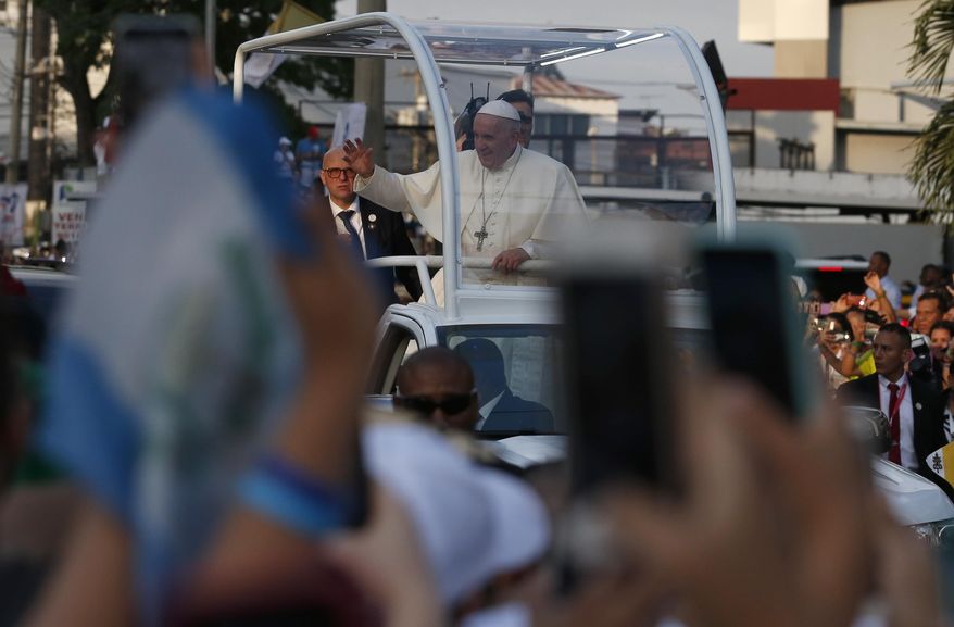 Poeple take pictures with their mobile phones as Pope Francis rides the pope mobile through the streets of Panama City, Panama, Wednesday, Jan. 23, 2019. Pope Francis is in Panama to attend World Youth Day, the church's once-every-three-year pep rally that aims to invigorate the next generation of Catholics in their faith. (AP Photo/Rebecca Blackwell)