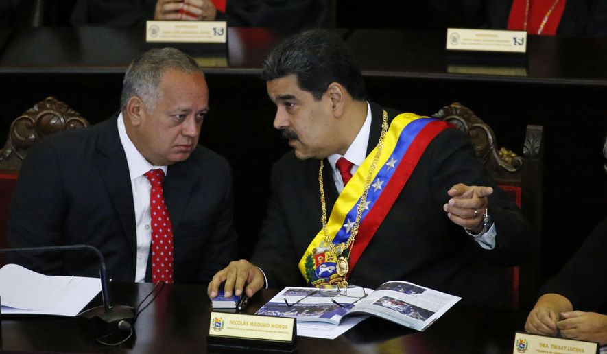 Venezuelan President Nicolas Maduro, right, speaks with Constitutional Assembly President Diosdado Cabello at the Supreme Court during an annual ceremony that marks the start of the judicial year in Caracas, Venezuela, Thursday, Jan. 24, 2019. Cabello and other high-ranking allies pledged to stand behind Maduro and denounced Juan Guaido who declared himself interim president on Wednesday. (AP Photo/Ariana Cubillos)
