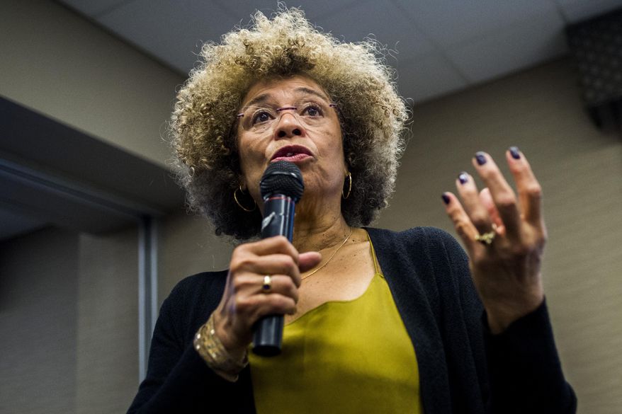 In this Feb. 19, 2015 file photo, Angela Davis speaks during her visit to the University of Michigan-Flint, in Flint, Mich.  An Alabama civil rights museum has reversed course after a public outcry and has decided to give political activist Angela Davis an award that it offered then rescinded. The Birmingham Civil Rights Institute said in a statement Friday, Jan. 25, 2019,  that its board has voted to reaffirm Davis as the recipient of the human rights award.(Jake May/The Flint Journal via AP)