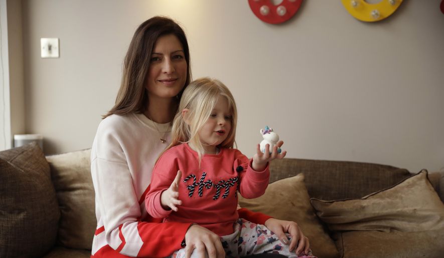 In this Wednesday, Jan. 23, 2019, photo, Victoria Mickleburgh and her daughter Grace pose for photographs at their home in Cobham on the outskirts of southwest London. Things are already tough for Mickleburgh, whose 3-year-old daughter Grace, has Type 1 diabetes and needs insulin daily. Drug supplies are already stretched because of market forces that have little to do with Brexit. Now pharmacists are concerned that shortages of life-saving medicines may occur if Britain can't negotiate a divorce deal. (AP Photo/Matt Dunham)