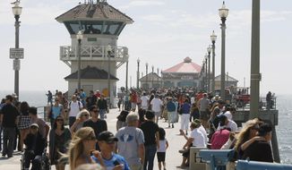 FILE - In this Sept. 5, 2011, file photo, pedestrians walk along the Huntington Beach Pier in Huntington Calif. California Gov. Gavin Newsom&#x27;s administration is using a new law for the first time in an attempt to force Southern California&#x27;s self-styled &amp;quot;Surf City USA&amp;quot; to meet housing goals. The administration on Friday, Jan. 25, 2019, said it is suing Huntington Beach under the law that took effect Jan. 1. The measure was passed in 2017 as part of a package of bills intended to address the state&#x27;s severe housing shortage and homelessness problem. (Armando Brown/The Orange County Register via AP, File)