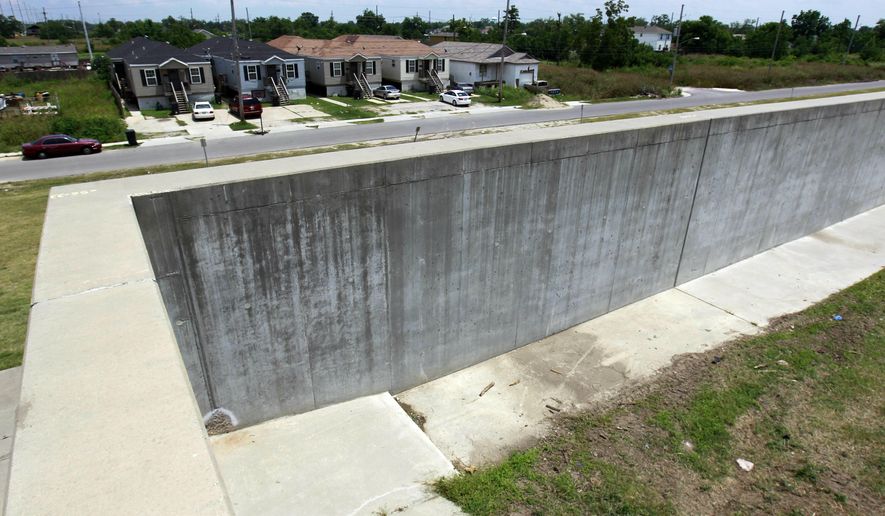 FILE - In this May 15, 2012 file photo, the new levee wall constructed with reinforced concrete, is shown at one of the breach sites from Hurricane Katrina, in the Lower 9th Ward in New Orleans. Louisiana's estimated share of the costs for federal levee work in the New Orleans area has ballooned to $3 billion because the U.S. Army Corps of Engineers is charging interest on the debt. Louisiana's first payment is due in August 2020, with $100 million estimated to be owed annually for 30 years.(AP Photo/Gerald Herbert, File)