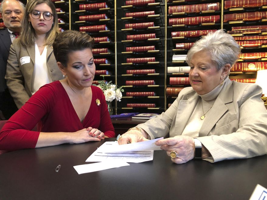 Heather French Henry, left, watches as the Secretary of State's Director of Administration and Elections Mary Sue Helm reviews her paperwork to file for statewide office on Friday, Jan. 25, 2019, in Frankfort, Ky. Henry filed to run for Secretary of State on Friday as a Democrat. A former Miss America, Henry was the Commissioner of the Kentucky Department of Veterans Affairs under former Democratic Gov. Steve Beshear and the deputy commissioner under Republican Gov. Matt Bevin. (AP Photo/Adam Beam)