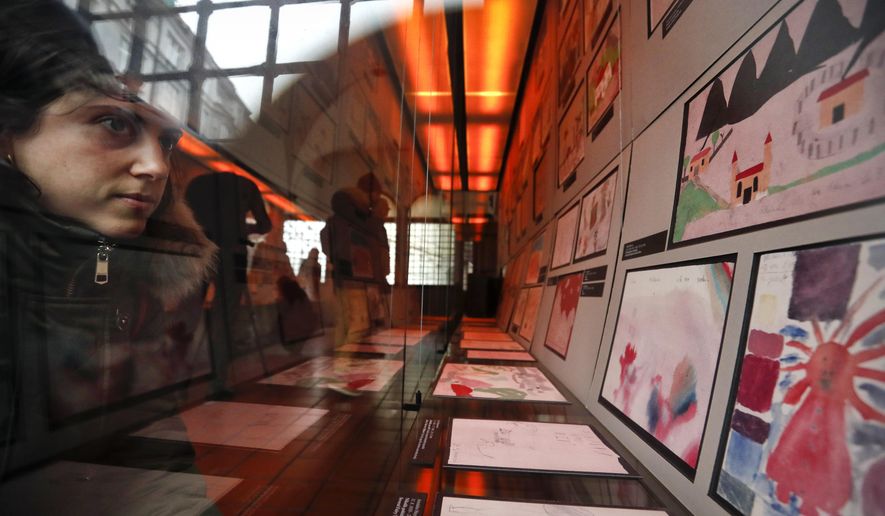 A visitor looks at the collection of drawings at the Jewish Museum in Prague, Czech Republic, Thursday, Jan. 24, 2019, made by Jewish children who passed through the Terezin Ghetto during WWII. A unique collection of some 4,500 drawings by children who were interned at the Theresienstadt concentration camp during the Holocaust still attracts attention even after 75 years since their creation. The drawings depict the everyday life as well hopes and dreams of returning home. (AP Photo/Petr David Josek)