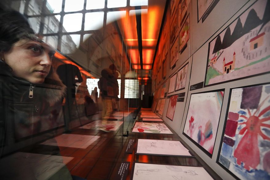 A visitor looks at the collection of drawings at the Jewish Museum in Prague, Czech Republic, Thursday, Jan. 24, 2019, made by Jewish children who passed through the Terezin Ghetto during WWII. A unique collection of some 4,500 drawings by children who were interned at the Theresienstadt concentration camp during the Holocaust still attracts attention even after 75 years since their creation. The drawings depict the everyday life as well hopes and dreams of returning home. (AP Photo/Petr David Josek)