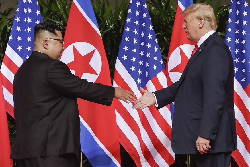 FILE - In this June 12, 2018, file photo, U.S. President Donald Trump reaches to shake hands with North Korea leader Kim Jong Un at the Capella resort on Sentosa Island in Singapore. (AP Photo/Evan Vucci, File)