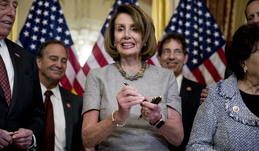 House Speaker Nancy Pelosi of Calif., accompanied by House Democratic members stand after signs a deal to reopen the government on Capitol Hill in Washington, Friday, Jan. 25, 2019. The measure now goes to the White House for President Donald Trump to sign.  (AP Photo/Andrew Harnik)