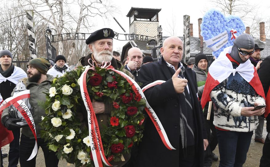 Polish far-right activists enter the former German Nazi death camp Auschwitz-Birkenau, on International Holocaust Remembrance Day in Oswiecim, Poland, Sunday, Jan. 27, 2019.(AP Photo)