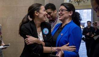 Rep. Alexandria Ocasio-Cortez, D-N.Y., left, and Rep. Rashida Tlaib, D-Mich., right, laugh as they wait for other freshman Congressmen to deliver a letter calling to an end to the government shutdown to deliver to the office of Senate Majority Leader Mitch McConnell of Ky., on Capitol Hill in Washington, Wednesday, Jan. 16, 2019. (AP Photo/Andrew Harnik)