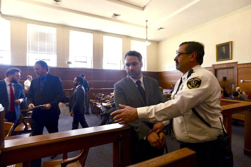Mark Fitzgerald, of Ashland, Mass., is led by a district court officer, Monday, Jan. 28, 2019, in Waltham, Mass., where he was arraigned on charges including assault with a dangerous weapon. Two Massachusetts men involved in an apparent case of road rage in which one drove at speeds of up to 70 mph with the other clinging to the hood of his car, have been arraigned. (Faith Ninivaggi/MediaNews Group/Boston Herald via AP, Pool)