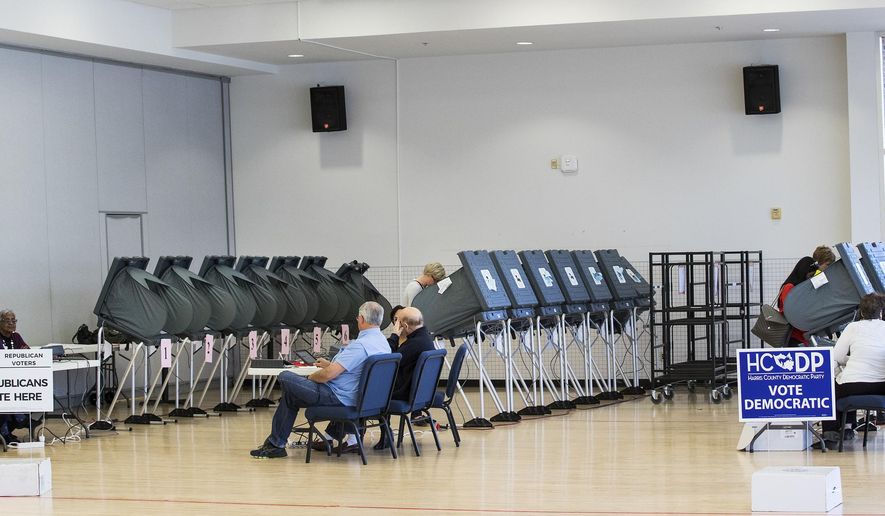 FILE - In this March 6, 2018 file photo, voters take to the polls in the primary election at West University Elementary in Houston. The ACLU and other groups slammed Texas elections officials who say they found 95,000 people identified as non-citizens who had a matching voter registration record. Texas Attorney General Ken Paxton now says many of them could have become citizens and voted legally. (Brett Coomer/Houston Chronicle via AP, File)