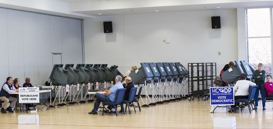 FILE - In this March 6, 2018 file photo, voters take to the polls in the primary election at West University Elementary in Houston. The ACLU and other groups slammed Texas elections officials who say they found 95,000 people identified as non-citizens who had a matching voter registration record. Texas Attorney General Ken Paxton now says many of them could have become citizens and voted legally. (Brett Coomer/Houston Chronicle via AP, File)