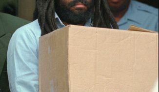 Death row inmate and convicted murderer Mumia Abu-Jamal leaves Philadelphia&#39;s City Hall after a hearing July 12, 1995. The international human rights organisation Amnesty International Wednesday Aug 2 1995 repeated their call for a commutation of his death sentance.Abu-Jamal was convicted of killing a police officer in 1981. (AP Photo/Chris Gardner)