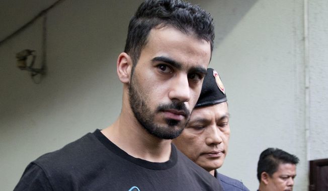 FILE - In this Tuesday, Dec. 11, 2018, file photo, prison guards escort Bahraini football player Hakeem al-Araibi from a court in Bangkok, Thailand. Thailand officially received a request from Bahrain to extradite a detained soccer player who has refugee status in Australia. The foreign ministry says the request for extraditing Hakeem al-Araibi has been forwarded to prosecutors for deliberation. (AP Photo/Gemunu Amarasinghe, File)