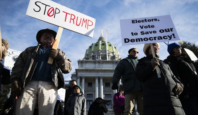 Protesters demonstrate ahead of Pennsylvania&#x27;s 58th Electoral College at the state Capitol in Harrisburg, Pa., Monday, Dec. 19, 2016. The demonstrators were waving signs and chanting in freezing temperatures Monday morning as delegates began arriving at the state Capitol to cast the state&#x27;s electoral votes for president. (AP Photo/Matt Rourke) **FILE**