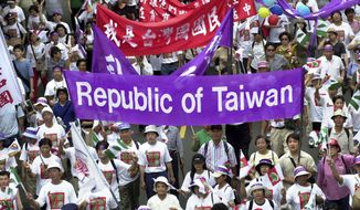 FILE - In this May 11, 2002, file photo, pro-Taiwan supporters carry banners during a march of about 8,000 people asking the government to change the island&#39;s official name from the &amp;quot;Republic of China&amp;quot; to &amp;quot;Taiwan,&amp;quot; in Taipei, Taiwan. The residents of this self-governing island, with its vibrant and well-established democracy, seem as much inclined as ever to resist China’s demands despite rising political, economic and military threats from Beijing. (AP Photo/Jerome Favre, File)
