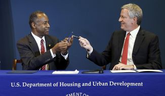 Housing and Urban Development Secretary Ben Carson, left, and New York Mayor Bill de Blasio exchange pens after doing a ceremonial signing of an agreement about New York City&#x27;s public housing system, the nation&#x27;s largest, in New York, Thursday, Jan. 31, 2019. (AP Photo/Richard Drew)