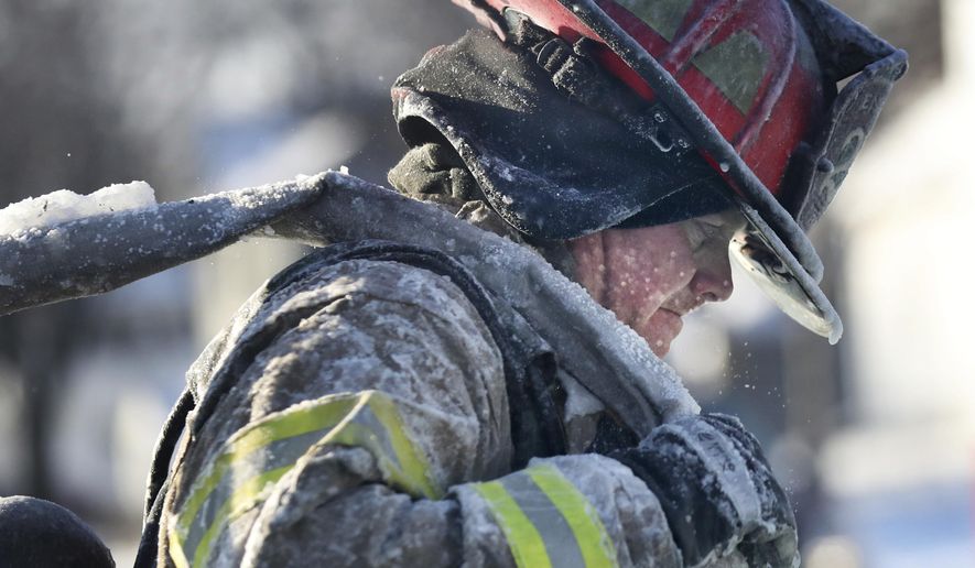A St. Paul firefighter works at the scene of a house fire during a arctic deep freeze on Wednesday, Jan. 30, 2019, In St. Paul, Minn. (David Joles/Star Tribune via AP)