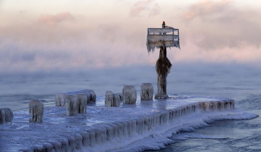 A harbor light is covered by snow and ice on the Lake Michigan at 39th Street Harbor, Wednesday, Jan. 30, 2019, in Chicago. A deadly arctic deep freeze enveloped the Midwest with record-breaking temperatures on Wednesday, triggering widespread closures of schools and businesses, and prompting the U.S. Postal Service to take the rare step of suspending mail delivery to a wide swath of the region. (AP Photo/Nam Y. Huh)